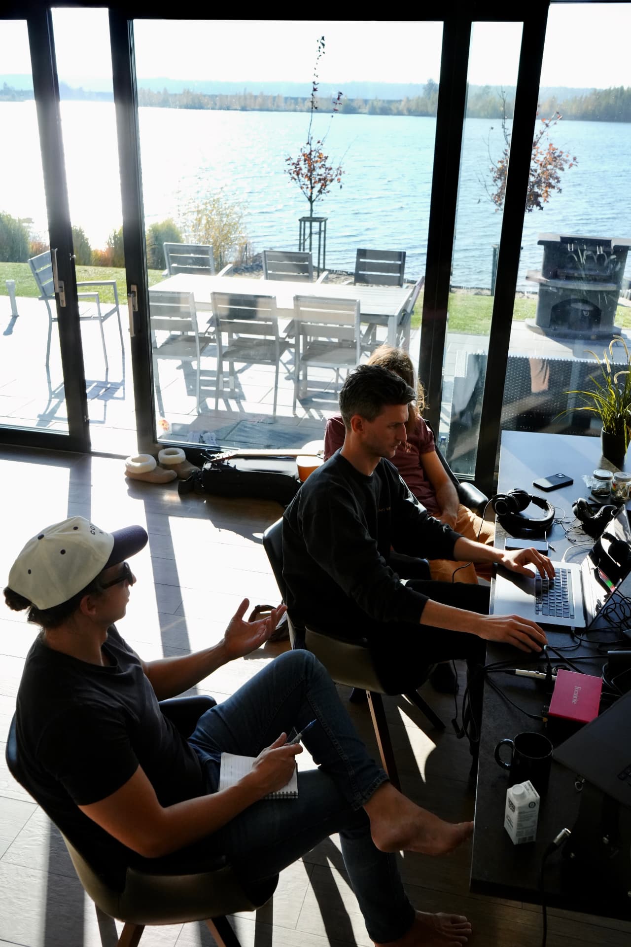 A writing session with musicians in front of a large window over the water